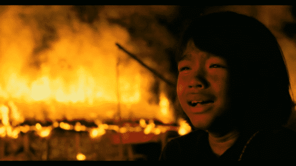 First They Killed My Father - Loung (Sareum Srey Moch) as a village burns in the background