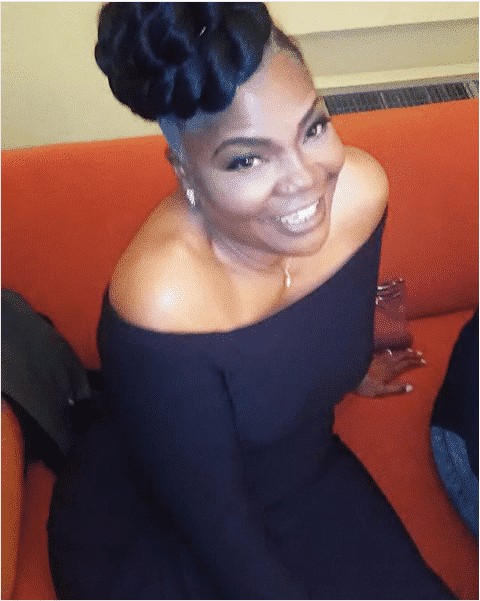 Mo'Nique smiling in a dress, make up done, and hair clearly ready for the stage.