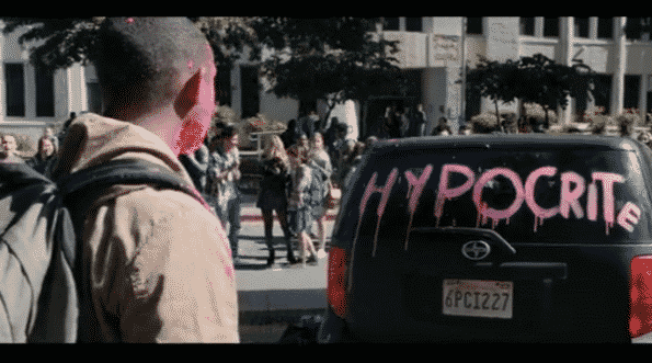 Marcus staring at his car which has "Hypocrite" written in pink on the back.