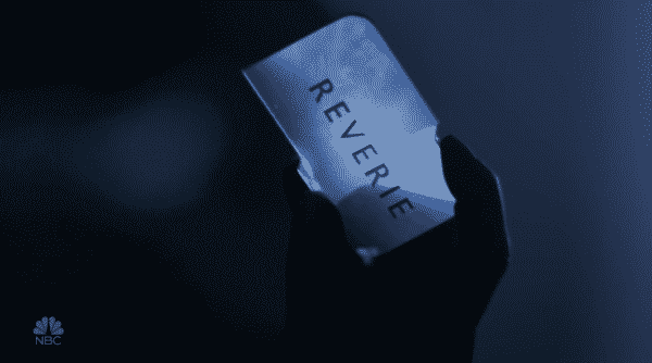 Mara holding a card for Reverie. | Reverie Title Card Mara holding a card for Reverie.