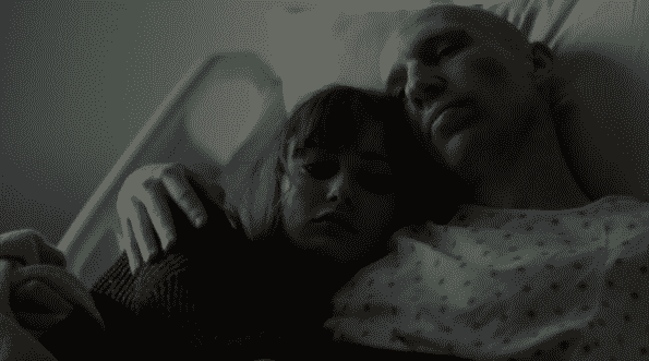 Tess and Sasha cuddling in his hospital bed.