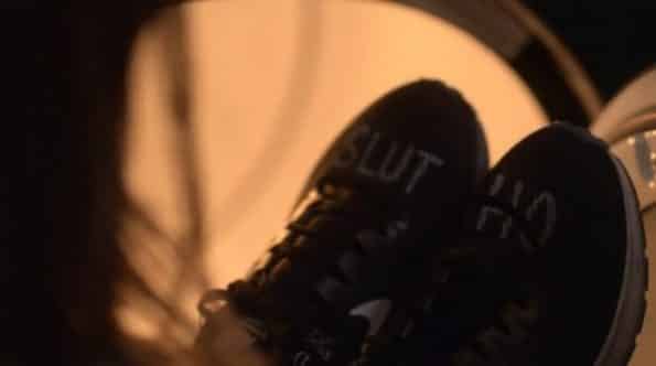 Casey's running sneakers with the word "Slut" and "Ho" written on them.