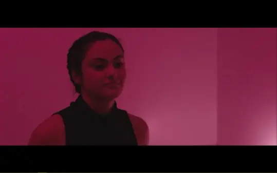 Morgan (Camila Mendes) in a rosy colored room.