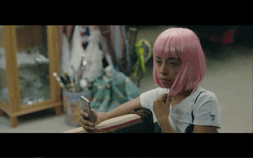 Nikki (Hayley Law), with a pink wig, judging Blake's Halloween party outfits.