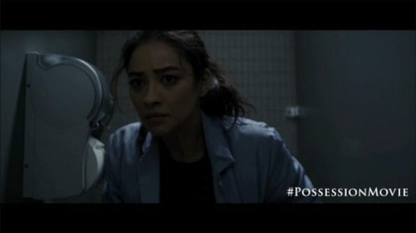 Megan (Shay Mitchell) hearing something while on the toilet.