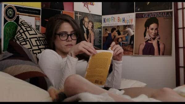 Luce (Olivia Luccardi) reading in bed.