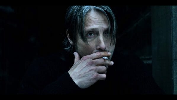 Duncan (Mads Mikkelsen) smoking a cigarette.