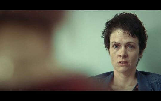 Sarah (Lu Corfield) looking towards Maeve at the abortion clinic.