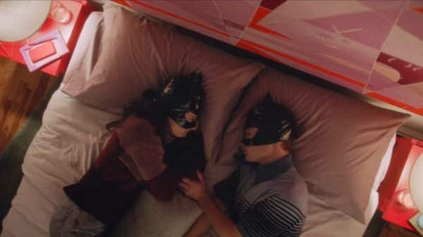 Tiff and Pete in bed, with masks on.