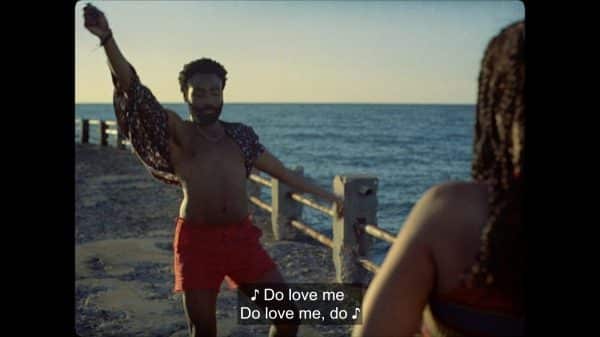 Deni (Donald Glover) singing and dancing to entertain Kofi.