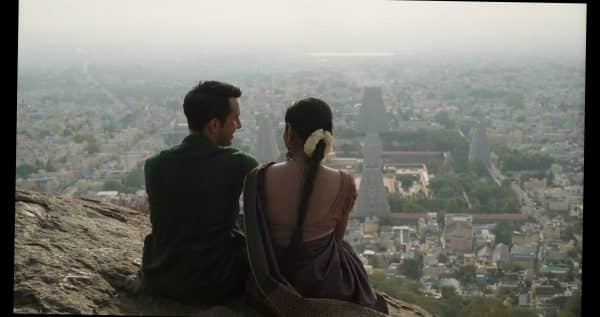 Kris (Christopher Gurusamy) and Valli (Sudgarma Vaithiyanathan) talking to one another, looking out towards the city.