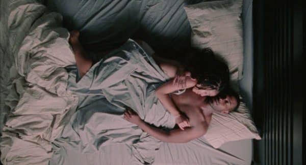 Ayanna (Zora Howard) and Isiah (Joshua Boone) in bed together.