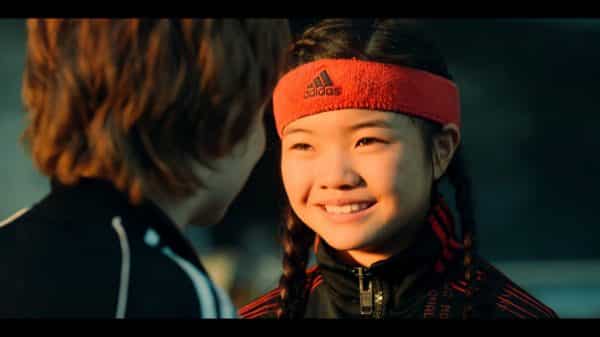 Zhenzhen (Miya Cech) smiling at Alex (Jack Gore)