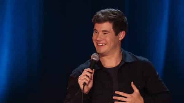 Adam Devine looking touched by something said.