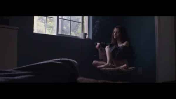 Alice (India Eisley) sitting on a chair, looking out the window, after sleeping with Adam.