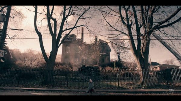 June sitting in front of the burnt Waterford house.