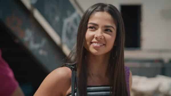 Rita (Bruna Mascarenhas) smiling at one of Nando's peers.