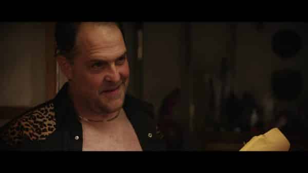Ken (Dave Maldonado) smiling at Liza as he pays her for sex.