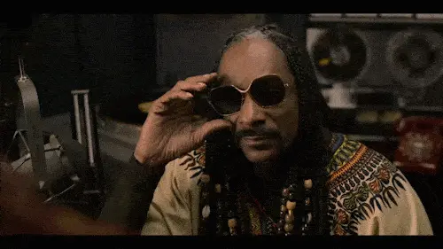 Roj (Snoop Dogg) lowering his glasses.