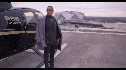 TI stepping off a helicopter and adjusting his jacket.
