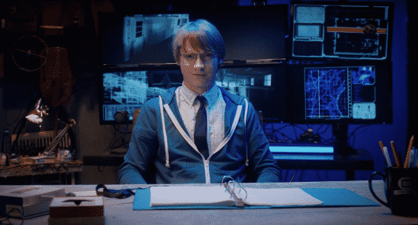 Calum Worthy (Doug) sitting at a desk.