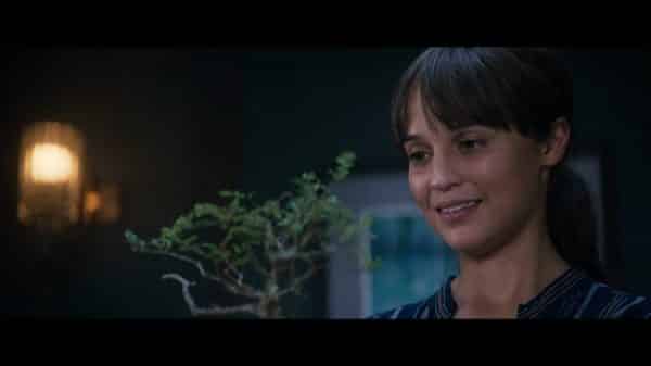 Lucy (Alicia Vikander) smiling as she receives a gift.