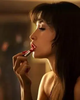 Selena Quintanilla (CHRISTIAN SERRATOS) putting on lipstick.