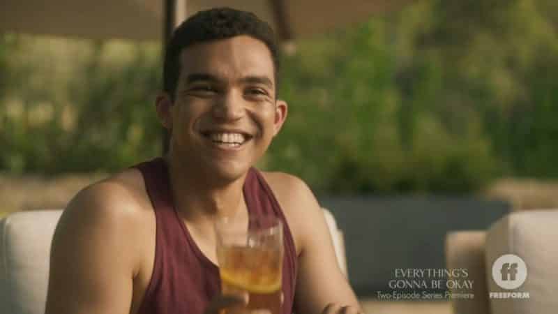 Alex (Adam Faison) smiling and drinking.