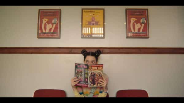 Lily hiding behind a Tank Girl comic.