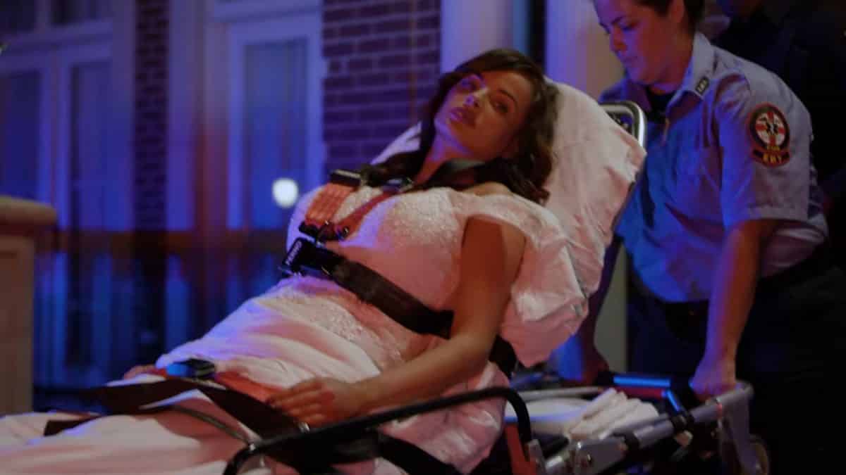 Mallory (Ashley Rickards) being carted away.