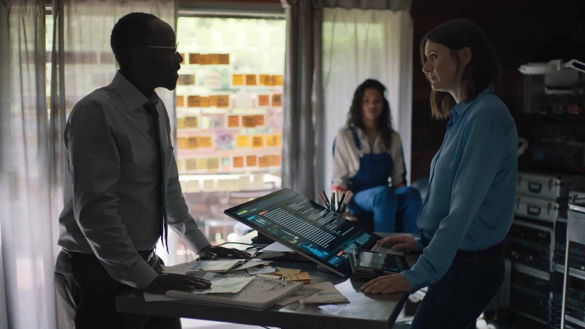 Martin (Don Cheadle), Aisha (Helena Howard), and Sharon (Emily Mortimer) talking in Sharon's home.