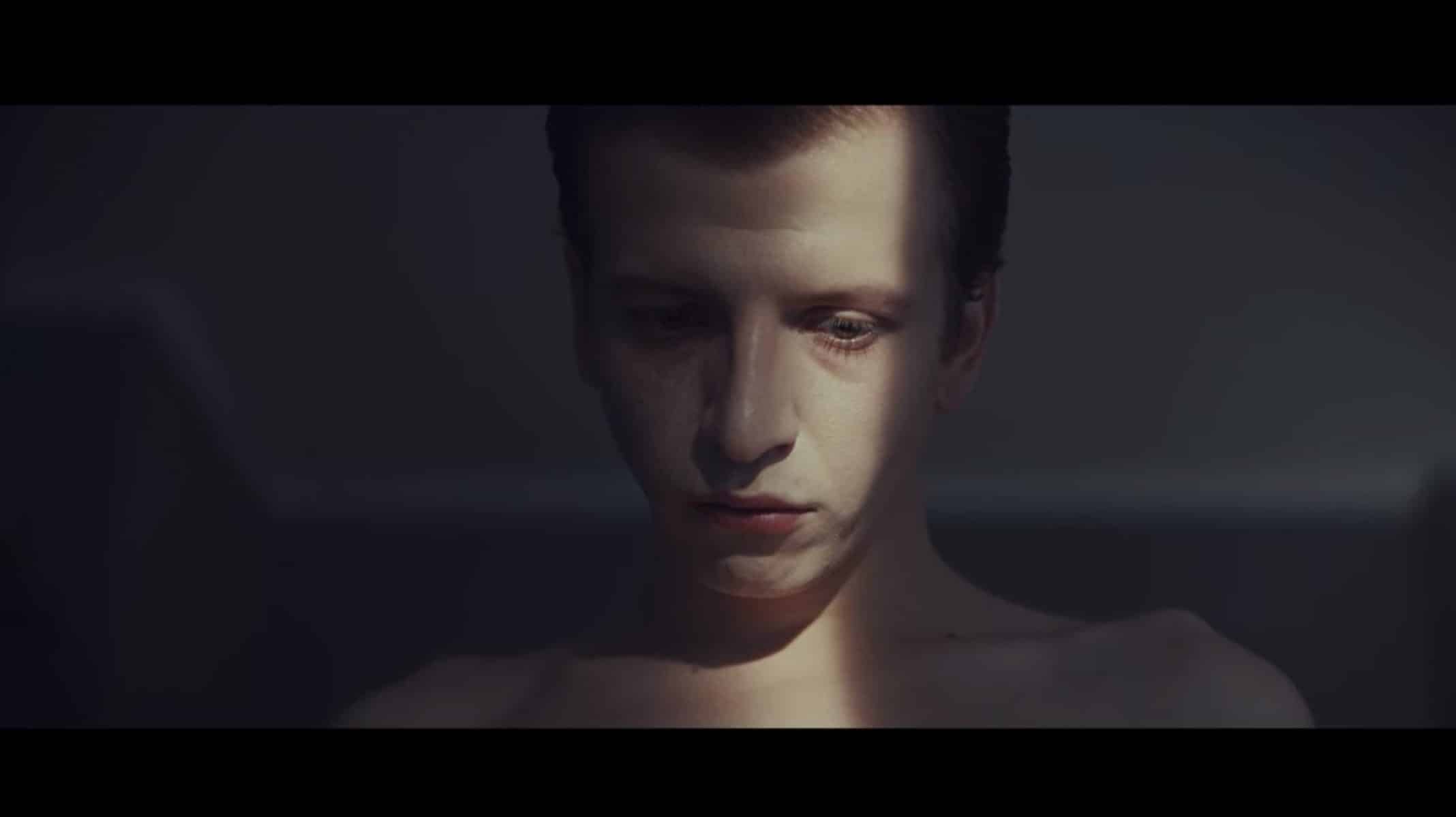 Tomek (Maciej Musialowski) with his shirt off and light over his eye.