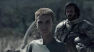 Mother (Amanda Collin) with a soldier behind her.
