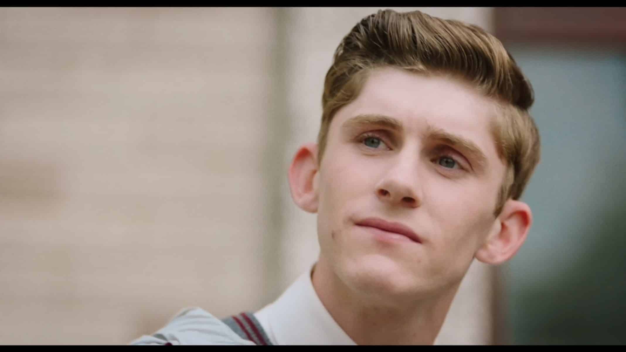 Eddie (Fionn O'Shea) sitting on stairs at school