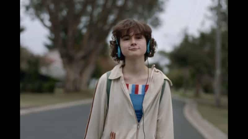 Nahla (Inez Curro) walking down a street, enjoying her music