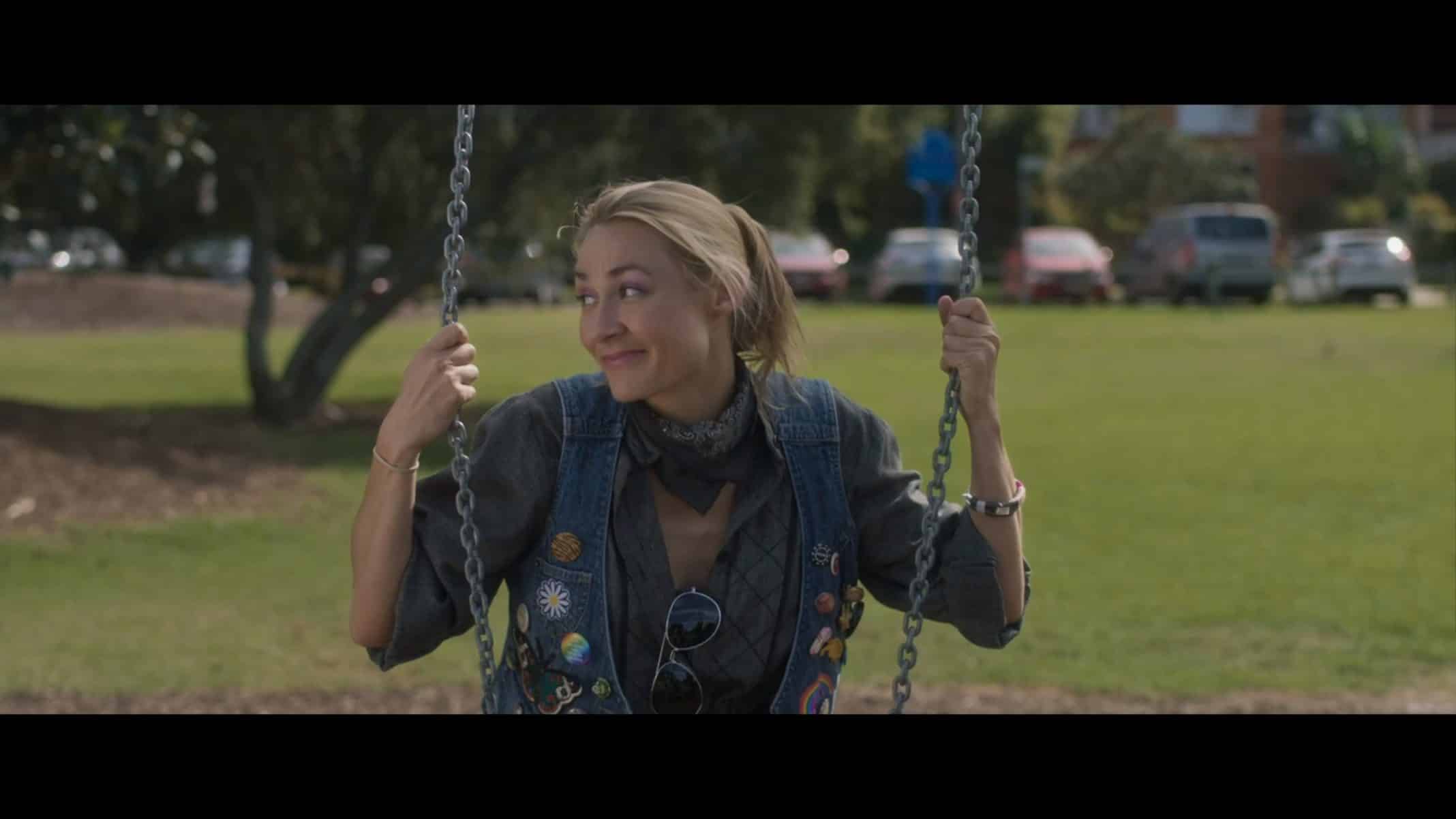 Tara (Julia Billington) sitting on a swing