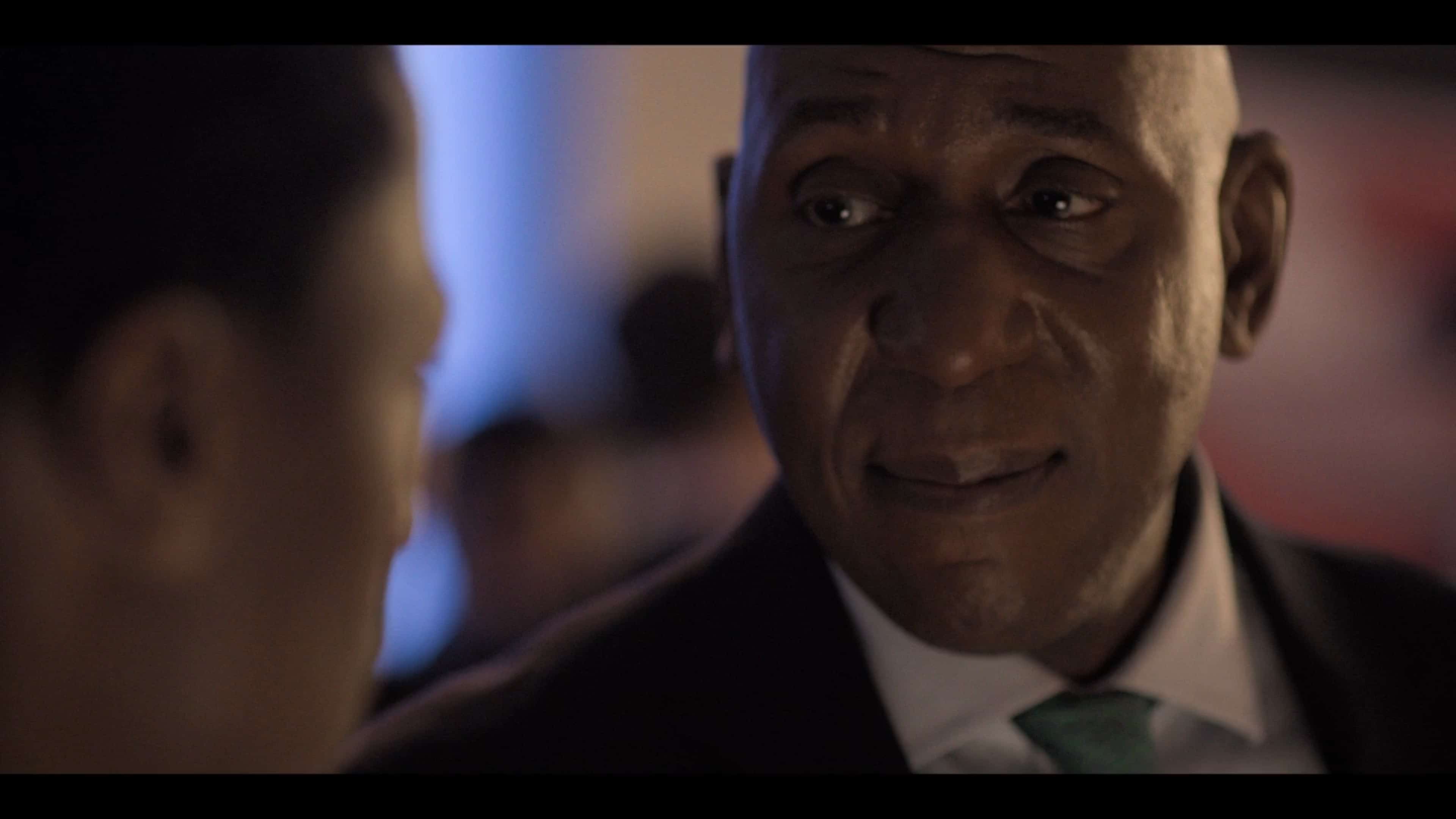 Lord Oki (Colin McFarlane) talking to Gus