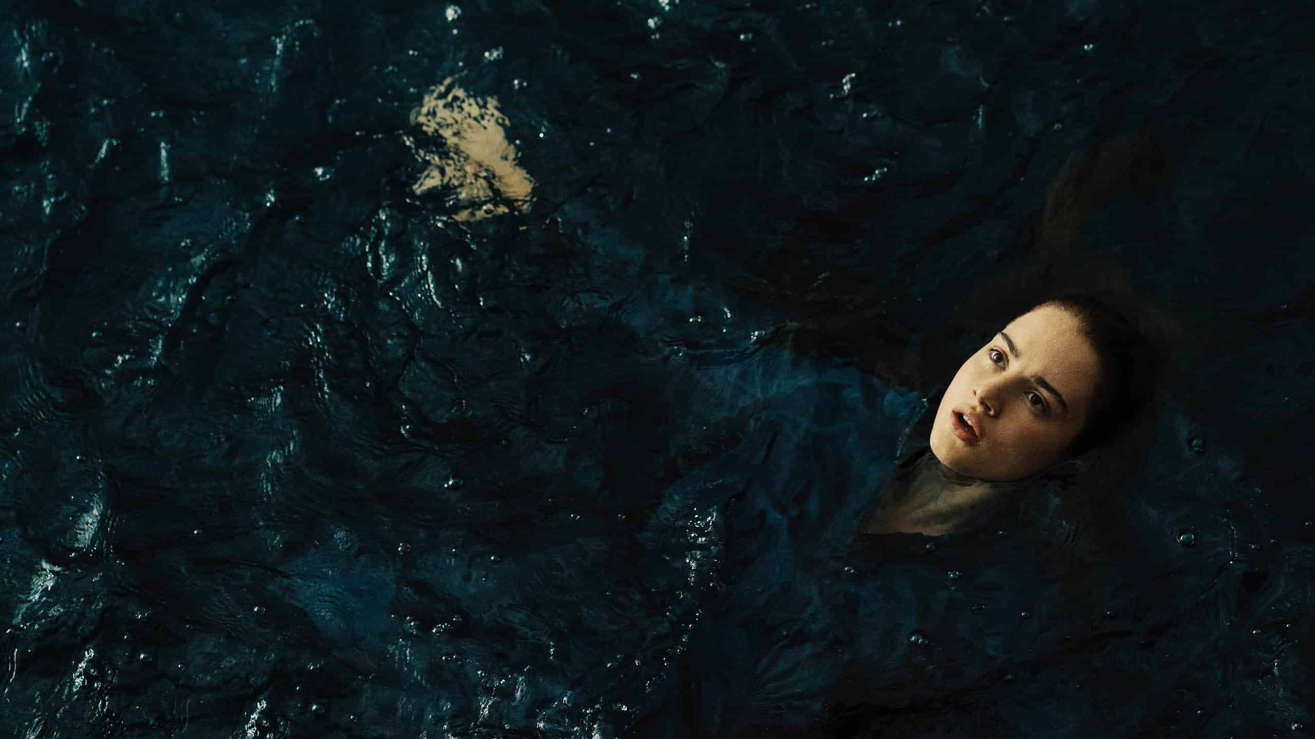 Ana (Grace Van Patten) floating in the water