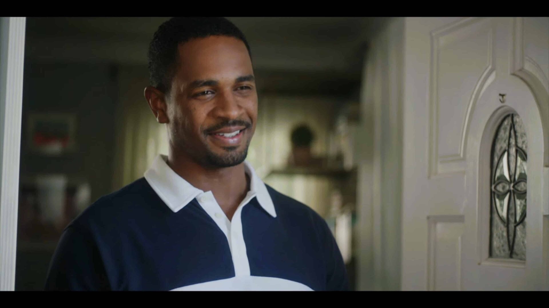 Doug (Damon Wayans Jr.) smiling, answering his door