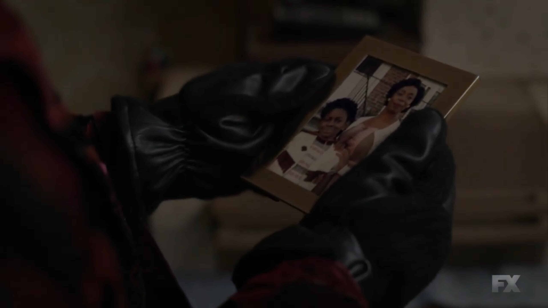 Elektra looking at a younger picture of herself with her mom