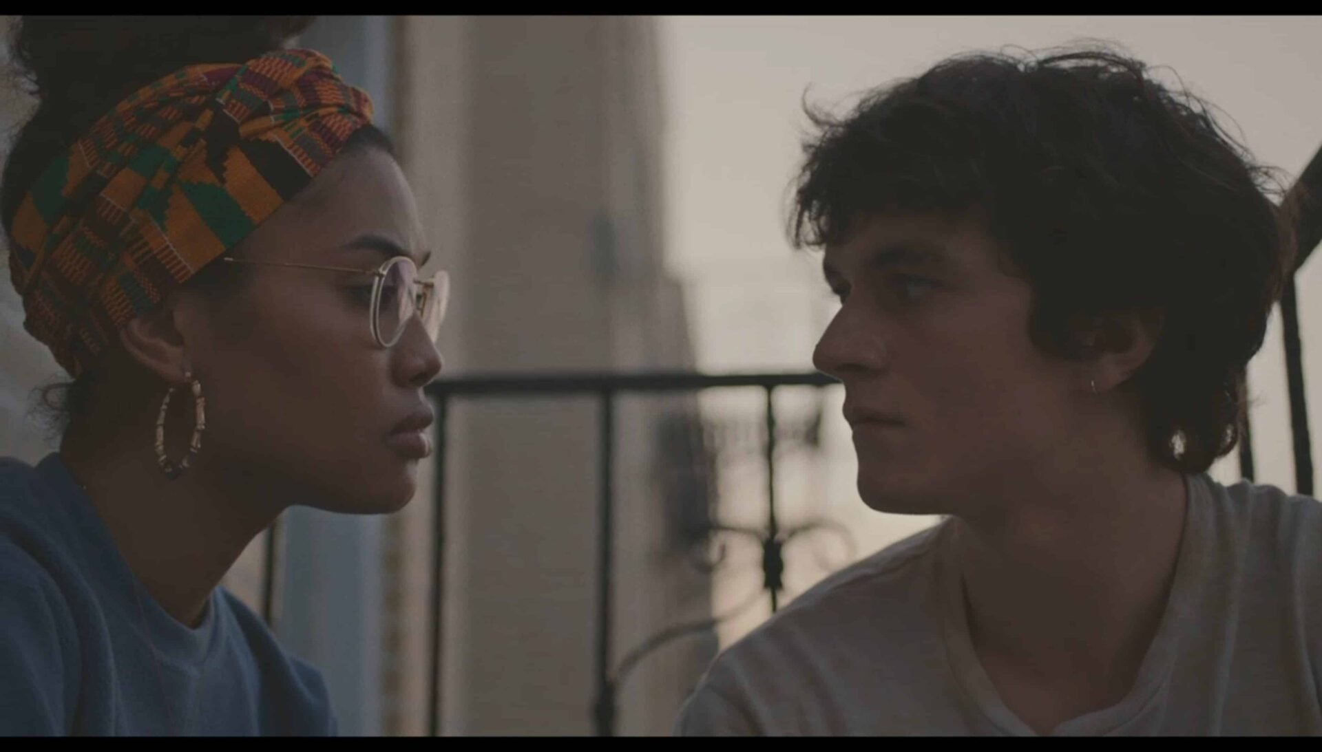 Wye (Leyna Bloom) and Paul (Fionn Whitehead) chilling outside her window