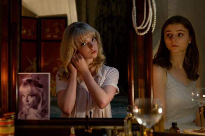 Sandie (Anya Taylor-Joy) looking in the mirror as Eloise (Thomasin McKenzie) watches her