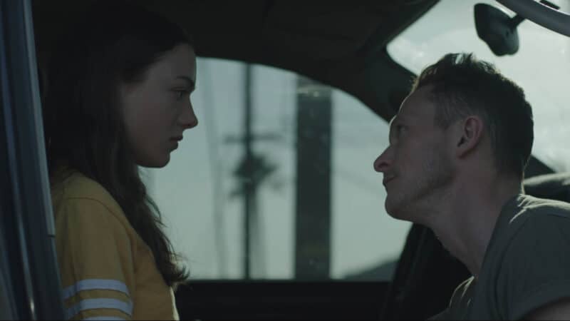 Lea (Lily McInerny) and Tom (Jonathan Tucker) talking in Tom's car