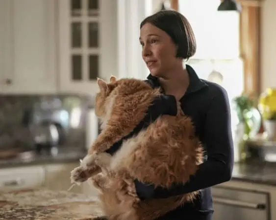 Olivia (Rebecca Henderson) holding a cat