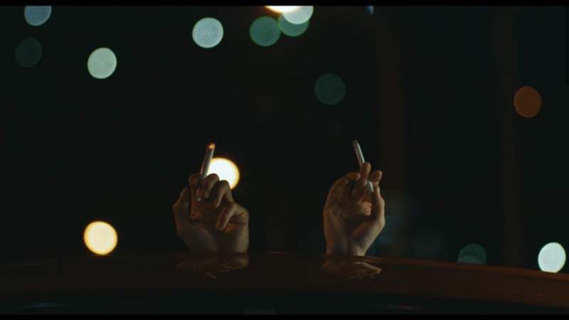 Two people holding cigarette in the air