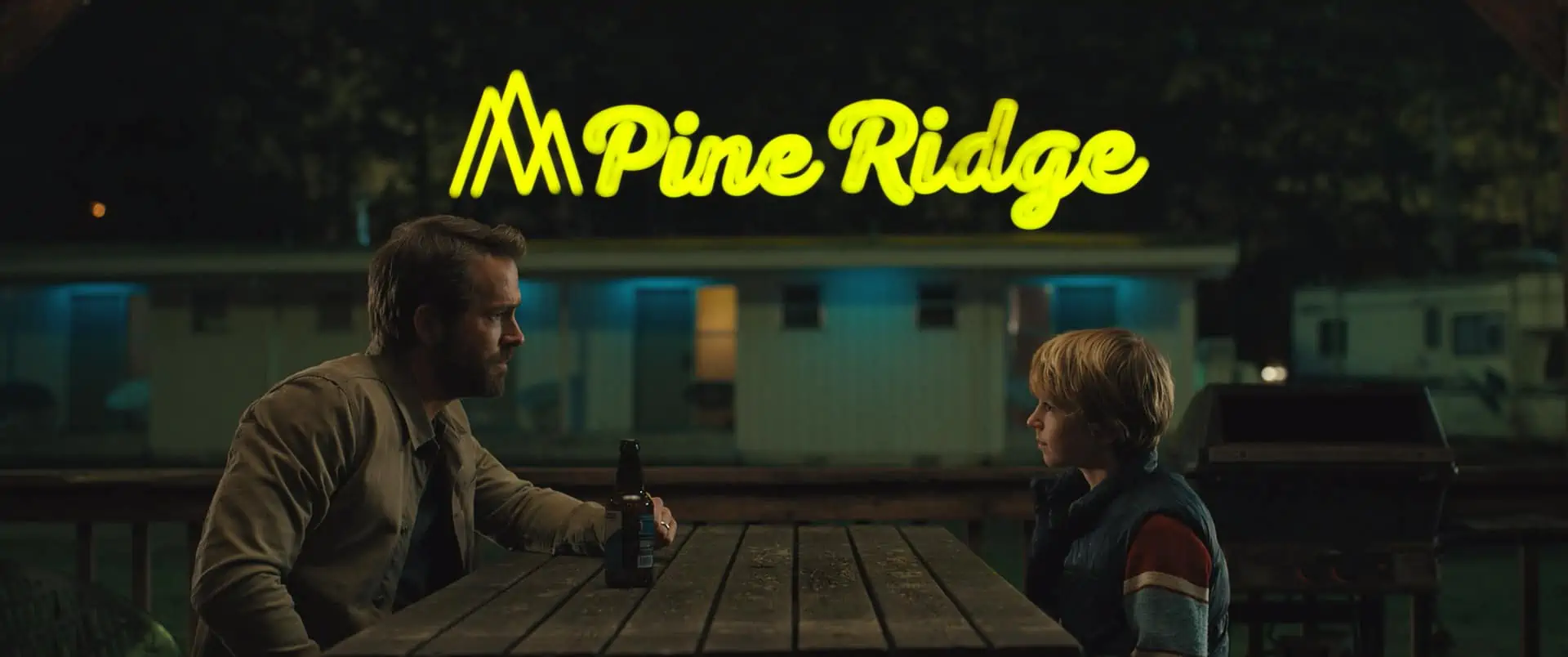 Adam 2050 (Ryan Reynolds) and Adam 2022 (Walker Scobell) sitting outside the Pine Ridge motel