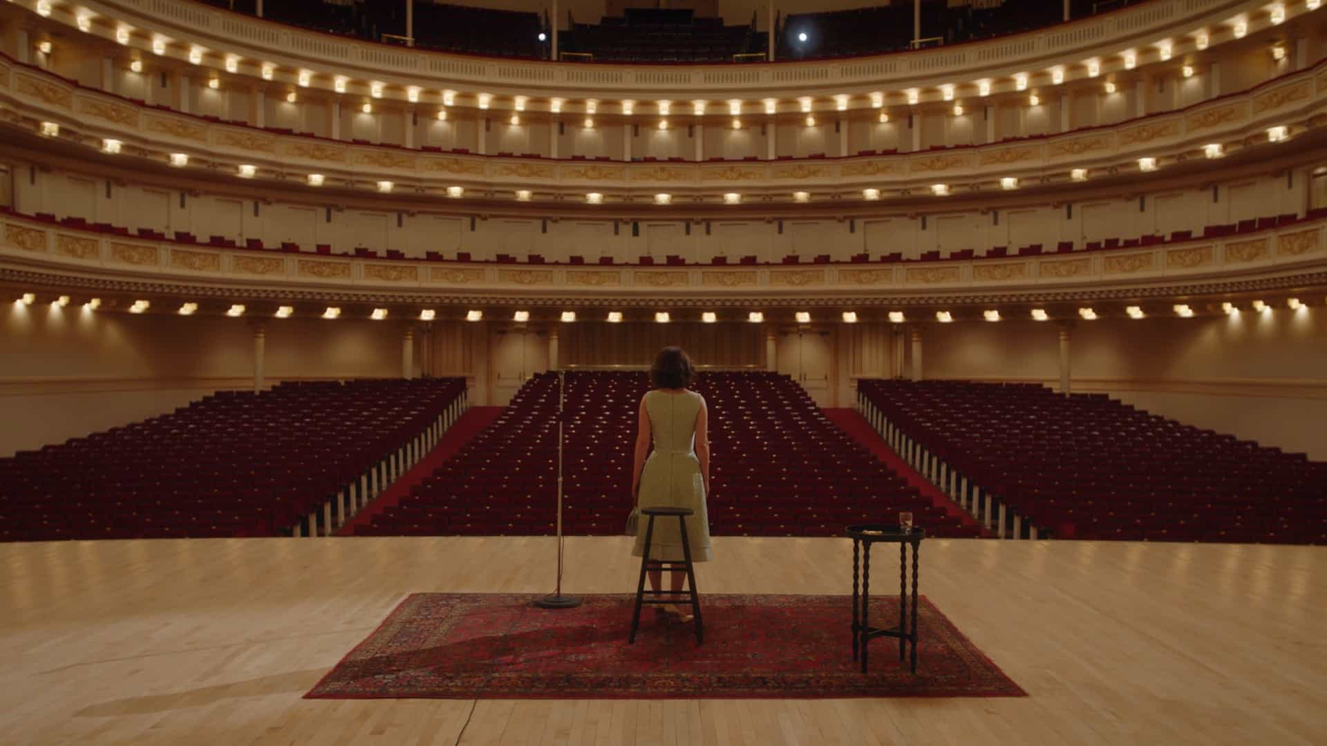 Miriam standing in Carnegie hall to a empty theater