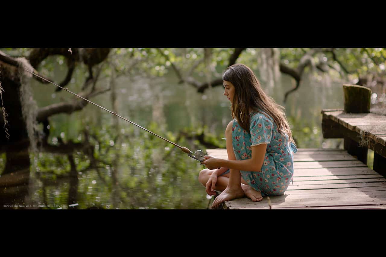 Kya (Daisy Edgar-Jones) fishing in the swamp barefoot