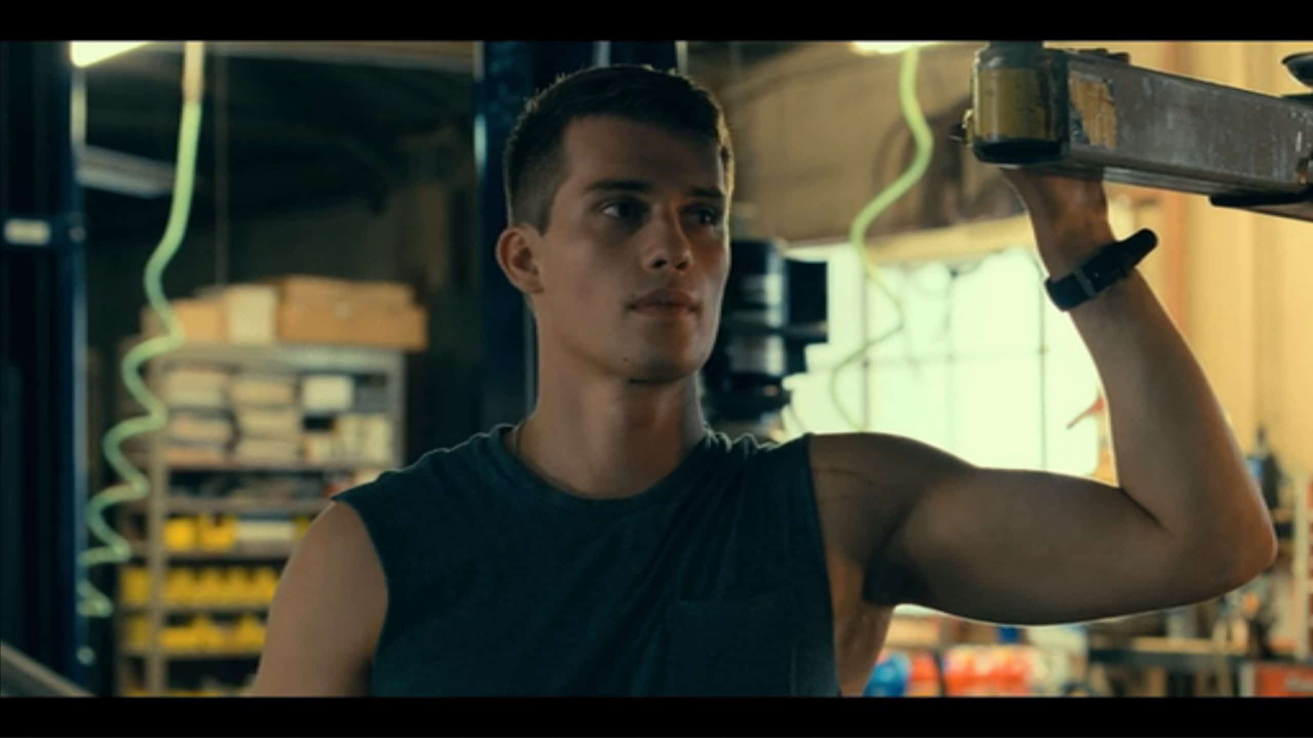 Luke (Nicholas Galitzine), with his arms out, in his father's shop