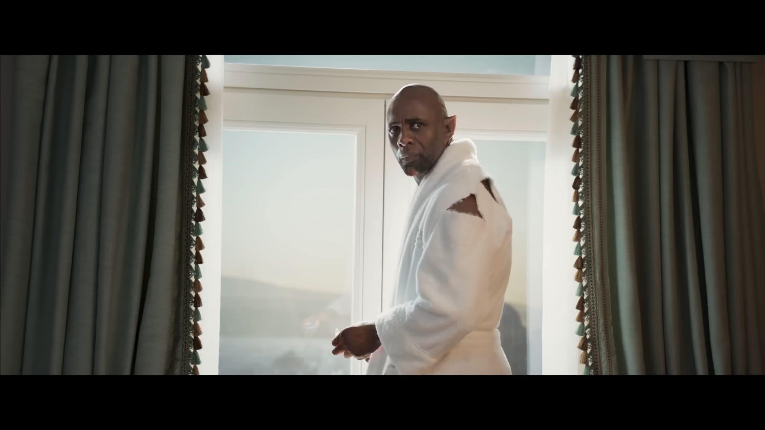 Djinn (Idris Elba) in a robe, telling his story